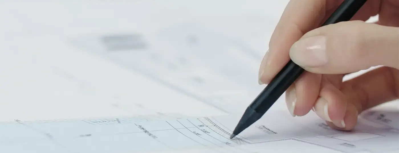 Hand mit Stift auf einem Bauplan